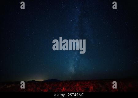 La via lattea che si innalza verticalmente dal paesaggio di notte Foto Stock