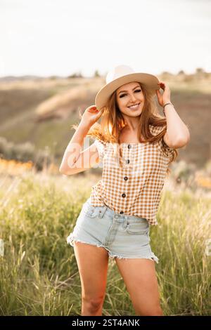 Una giovane donna allegra nella moda country gode di un'ora d'oro Foto Stock