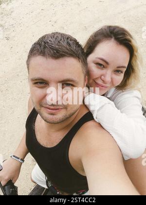 Una giovane coppia adulta sta facendo un selfie su uno scooter Foto Stock