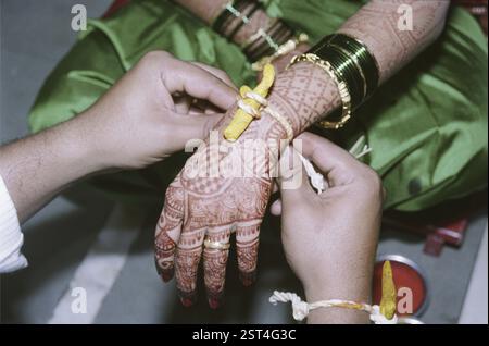 Sposa indiana e sposo indiano che eseguono vidhi rituali nella cerimonia di nozze maharashtriana Foto Stock
