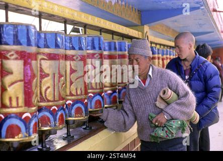 La popolazione tibetana è svolta a pregare ruote al monastero buddista, mcleodganj Foto Stock