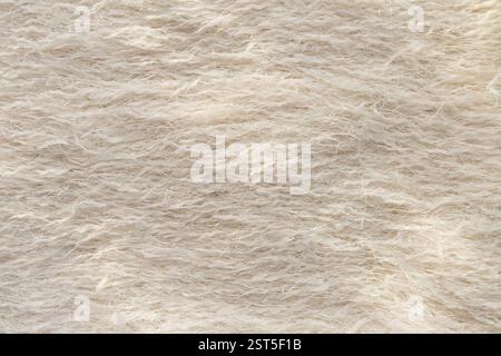 Un effetto macro di tessuto piuma beige con fili metallici. Foto Stock