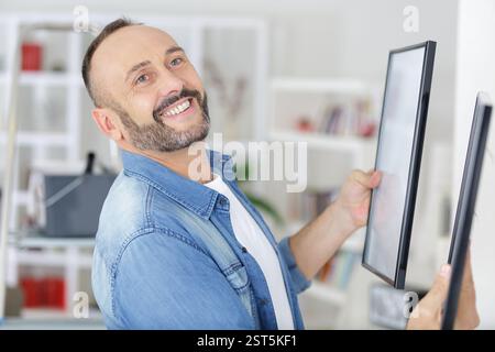 un uomo maturo attacca la cornice Foto Stock