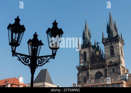 Una suggestiva vista della chiesa di architettura gotica europea con torreggianti guglie e un'ornata lampada da strada d'epoca in primo piano Foto Stock