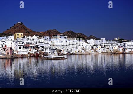 Haveli e case di colore bianco incontaminato riflesso nel lago Pushkar, Rajasthan, India, Asia Foto Stock