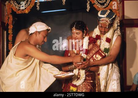 Sacerdote che offre lahya alla sposa e allo sposo eseguendo vidhi nella cerimonia nuziale udupi madhwa Brahmin, Karnataka, India, Asia Foto Stock