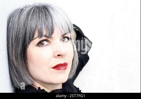 Il volto di una bella giovane donna con i capelli bianco-grigio Foto Stock