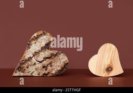 Cuori di legno con corteccia e senza corteccia su sfondo rosso Foto Stock