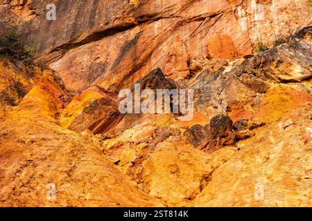 Formazione rocciosa di bauxite erosa con colori arancio brillanti in una miniera di bauxite abbandonata Foto Stock