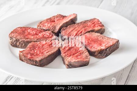 Tenera bistecca di mignon in filetto, perfettamente cotta, tagliata a fette ed elegantemente presentata su un piatto Foto Stock