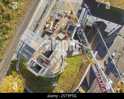 Vista dall'alto di un cantiere con gru e edifici circostanti, vicino a binari ferroviari e strade, estensione della stazione ferroviaria di Calw per Foto Stock