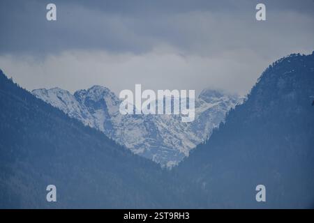 Vette innevate sotto un cielo nuvoloso, Ainring, alta Baviera Foto Stock