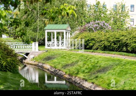 Giardino polacco nella tenuta di Derzhavin. Splendida fioritura primaverile. Stagno, ponte Foto Stock