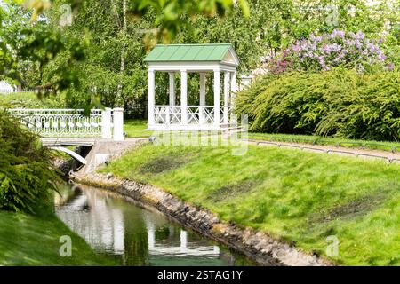 Giardino polacco nella tenuta di Derzhavin. Splendida fioritura primaverile. Stagno, ponte Foto Stock