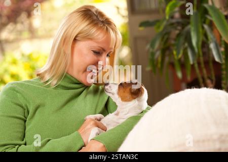 Donna e Jack Russell Terrier cucciolo godendo una giornata sul divano. Foto Stock