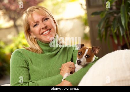 Donna e Jack Russell Terrier cucciolo godendo una giornata sul divano. Foto Stock