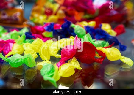 Caramelle colorate in involucri multicolore, messa a fuoco selettiva. Foto Stock
