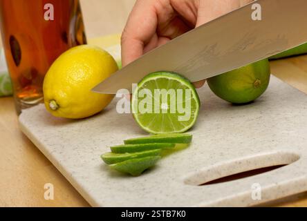 Affettare una calce su un tagliere. Foto Stock