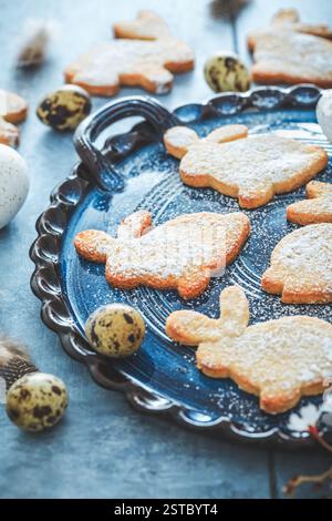 Biscotti fatti in casa con coniglietti di mandorle per Pasqua con uova di Pasqua in tonalità blu Foto Stock