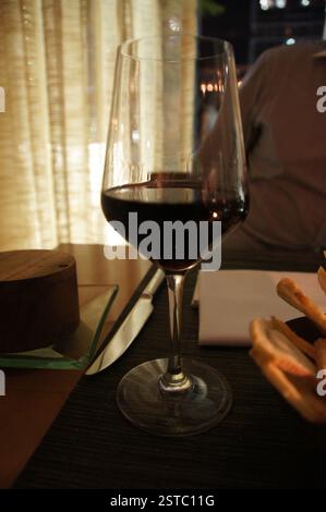 Bicchiere di vino rosso sul tavolo. Eleganti calici, magari brindisi per festeggiare. Possibile momento di relax, Miami. Foto Stock