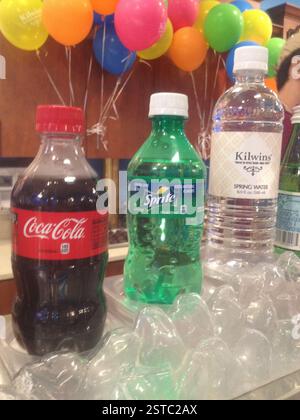 Tre bottiglie di bevande sul ghiaccio Miami Kilwins sullo sfondo. Coca-Cola, Sprite, festa in acqua sorgiva. Bevande rinfrescanti e ghiaccio. Foto Stock