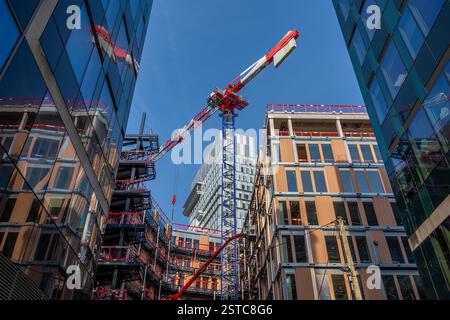 Vista ad angolo basso di un cantiere con gru. Concetti di industria edile, mercato immobiliare e norme tecniche per i nuovi edifici Foto Stock