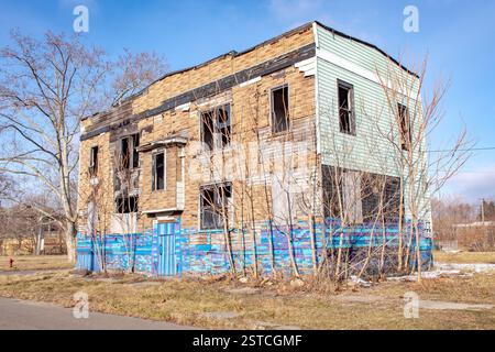 Vecchia casa abbandonata a bordo con uno schema blu a Detroit Michigan in una giornata nuvolosa Foto Stock
