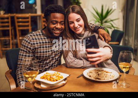 Due amici cenano al ristorante. Stanno facendo selfie. Foto Stock