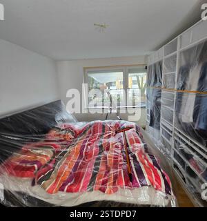Una moderna camera da letto con protezione in plastica per garantire che lo spazio rimanga pulito e ordinato Foto Stock