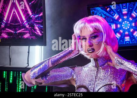 primo piano di bionda come cyber robot. Ragazza in brillante armatura argento al neon Foto Stock