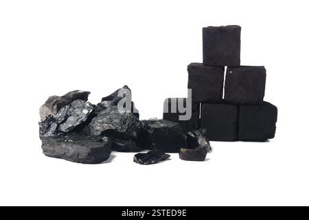 Una collezione di bricchette di carbone e carbone naturale impilate in modo ordinato, realizzate su uno sfondo bianco semplice che ne sottolinea la consistenza e il colore. Foto Stock