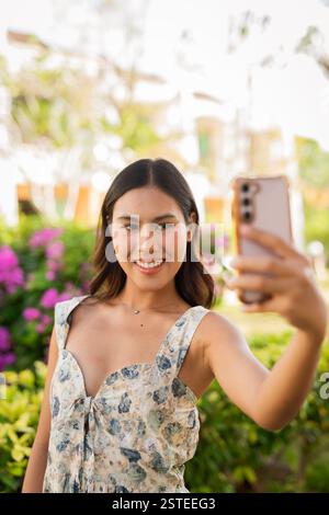 Giovane donna asiatica che usa il telefono all'aperto Foto Stock