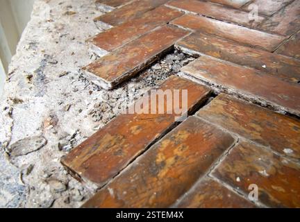 Un frammento di un vecchio pavimento in parquet con assi mancanti (profondità di campo ridotta) Foto Stock