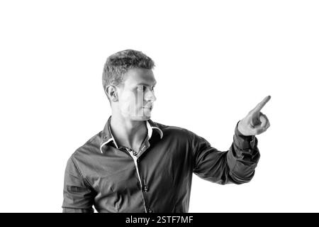 Giovane attraente che preme il pulsante immaginario in aria Foto Stock