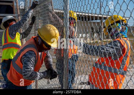 Guantánamo Bay, Cuba. 15 febbraio 2025. Gli appaltatori del Dipartimento della difesa degli Stati Uniti installano una recinzione per espandere il Centro operativo illegale di Alien Holding presso la stazione navale di Guantanamo Bay, 15 febbraio 2025 a Guantanamo Bay, Cuba. Homeland Security ha ordinato l'espansione per trattenere i migranti deportati fino a quando un altro paese non li riceverà. Crediti: PO1 Bryan mai/U. S Navy Photo/Alamy Live News Foto Stock