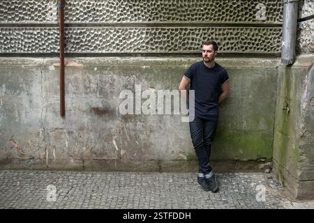Fiducioso uomo in posa di cimosa jeans Foto Stock