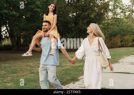 Famiglia felice che si diverte a passeggiare all'aperto nel parco Foto Stock