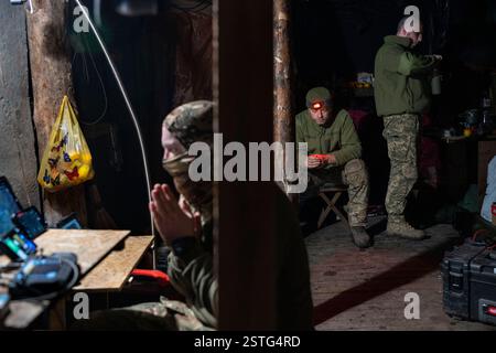 Ucraina. 22 dicembre 2024. All'interno di un bunker sotterraneo, gli operatori di droni ucraini volano un drone per colpire le posizioni russe in prima linea. La guerra tra Ucraina e Russia ha dimostrato quanto i droni economici e sacrificabili, come il kamikaze o i modelli che lanciano bombe, stiano rimodellando la guerra. Questi droni consentono attacchi precisi e a basso costo e si sono dimostrati estremamente efficaci nell'interrompere le operazioni nemiche. Di conseguenza, stanno cambiando le strategie militari, segnalando un futuro in cui i droni svolgono un ruolo centrale nel combattimento, riducendo la dipendenza dalle armi tradizionali e costose. (Immagine di credito: © Miguel Cande Foto Stock