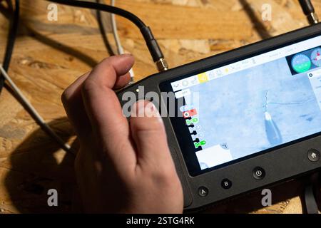 Ucraina. 22 dicembre 2024. All'interno di un bunker sotterraneo, un operatore di droni ucraino controlla un drone mentre lancia una bomba sulle posizioni russe bersaglio in prima linea. La guerra tra Ucraina e Russia ha dimostrato quanto i droni economici e sacrificabili, come il kamikaze o i modelli che lanciano bombe, stiano rimodellando la guerra. Questi droni consentono attacchi precisi e a basso costo e si sono dimostrati estremamente efficaci nell'interrompere le operazioni nemiche. Di conseguenza, stanno cambiando le strategie militari, segnalando un futuro in cui i droni svolgono un ruolo centrale nel combattimento, riducendo la dipendenza dalle armi tradizionali e costose. (CRE Foto Stock
