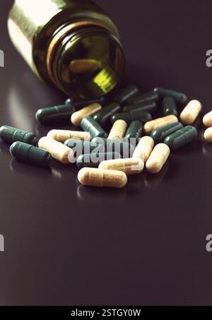 Vista angolare del flacone di pillole con prescrizione medica verde e bianca che fuoriesce su uno sfondo nero molto spazio per il testo Foto Stock