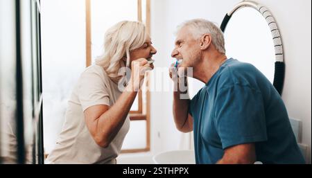 Pulizia, coppia senior e pulizia denti per igiene, sorriso o routine per prevenire cavità. Casa, anziani e spazzolino da denti per orale Foto Stock