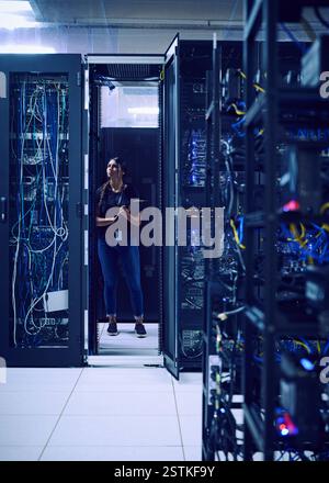 Tecnico donna in piedi nella sala server Foto Stock