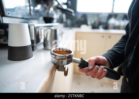 Barista azienda portafilter con caffè macinato Foto Stock
