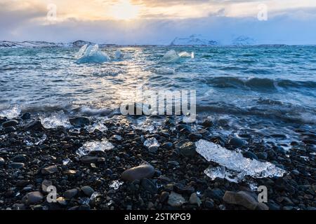 Piccoli iceberg sulle rive della laguna del ghiacciaio Jokulsarlon durante un tramonto. Jokulsarlon, Islanda orientale, Islanda, Nord Europa. Foto Stock