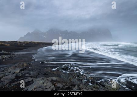 Vista delle onde del mare sulla spiaggia di fronte al monte Vestrahorn. Penisola di Stokksnes, Hofn, Austurland, Islanda, Europa. Foto Stock