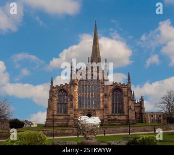 La facciata ovest del Rotherham Minster vista dai Minster Gardens, con la scultura Rotherham Heart of Steel in primo piano. South Yorkshire. REGNO UNITO Foto Stock