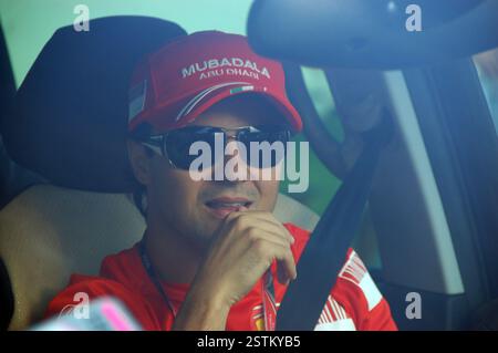 Il pilota di F1 Felipe massa con un berretto rosso Ferrari, guidando la sua Street car con la cintura di sicurezza, verso l'ingresso dell'Hungaroring Foto Stock