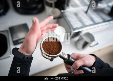 Barista azienda portafilter con caffè macinato Foto Stock