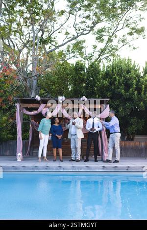A bordo piscina, amici anziani diversi che festeggiano in giardino riunendosi con gioia e spazio copia. anziani, diversi amici anziani, festeggiamenti, in ga Foto Stock