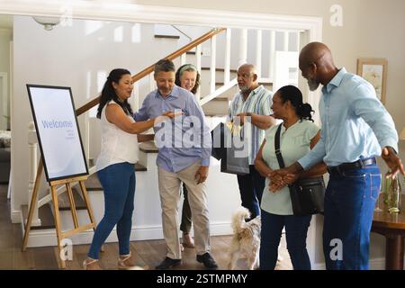 Accogliendo gli amici a casa, gruppi diversi che si divertono a radunarsi con il cane. Amicizia, celebrazione, diversità, animali domestici, ospitalità, felicità Foto Stock